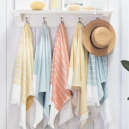 Striped fouta towels with fringes hanging on hooks